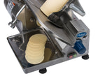 A compact slicer cuts a block of cheese into thin, even slices. Several slices collect in a stainless steel tray below the rotating blade. The machine has a blue dial, buttons, and the brand Chefpointe visible.