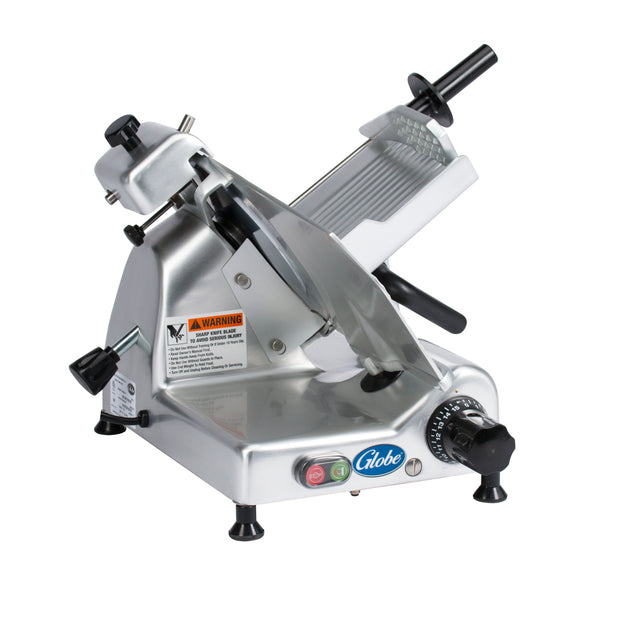 A commercial-grade silver food slicer with a 10" diameter knife, adjustable thickness knob, safety warning label, and black handle for pushing meat. The base has power buttons and a “Globe” logo. Its tilted design ensures efficient slicing.