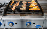A gas charbroiler with heavy duty cast-iron grates sizzles with shrimp skewers, seasoned fish fillets, and two salmon fillets topped with lemon slices. The stainless steel Globe grill features blue-accented knobs marked "ON" and "OFF.
