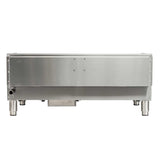 A stainless steel industrial countertop griddle viewed from the front, featuring a plain, smooth surface with a few visible screws, four sturdy legs, a small pipe on the left side, and a rectangular protrusion underneath.