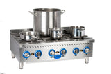 A stainless steel Globe GHP36G gas countertop hotplate with four burners, each featuring a control knob. Three metal pots and one large stockpot sit atop the burners. Blue and black dials line the front of this stove, which stands on four short legs.