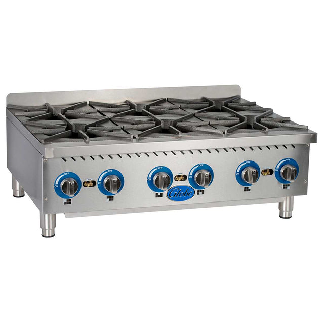 A stainless steel Globe GHP36G gas countertop hotplate with six black cast iron burners, blue and black control knobs, and a metallic backsplash. The 6 burner hotplate sits on short, sturdy legs with the brand name “Globe” on the front panel.