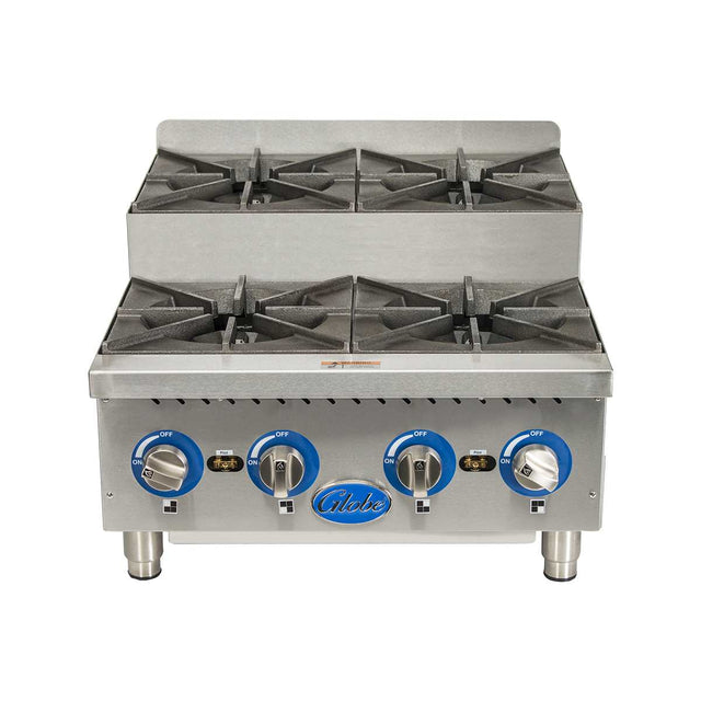 A commercial stainless steel gas countertop hotplate with four black cast iron open burners, blue and silver control knobs, and short metal legs. The front panel features the “Globe” logo at the center. Burners are arranged in two rows of two.