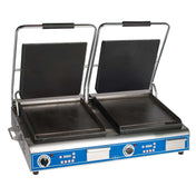 A double countertop electric grill and sandwich panini grill with two open, flat black cast iron smooth plates. Each side has a handle and control knobs with indicator lights on a blue front panel. Stainless steel body stands on four short legs.