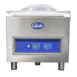 A stainless steel vacuum packaging machine with cylindrical legs, a transparent domed lid, and a blue control panel displaying buttons and digital screens. The front features the “Globe” logo above the control panel. Includes gas flush functionality.