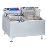 A stainless steel electric countertop fryer with 32 lbs. oil capacity, featuring dual tanks, two metal baskets, blue control panels, temperature dials, and a removable control box. Stands on four short legs; one basket sits in a tank while the other is above it.