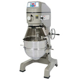 A large commercial floor mixer with a digital control panel, metal body, safety guard, and a stainless steel mixing bowl attached at the base. The planetary mixer has sturdy legs and a side hand crank for bowl adjustment.