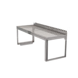 A stainless steel grill grate with foldable legs, a raised back edge, and an open, minimalist structure. This Vulcan-inspired design features parallel metal bars and is ideal as a removable wire rack for outdoor cooking or barbecuing over a fire pit.