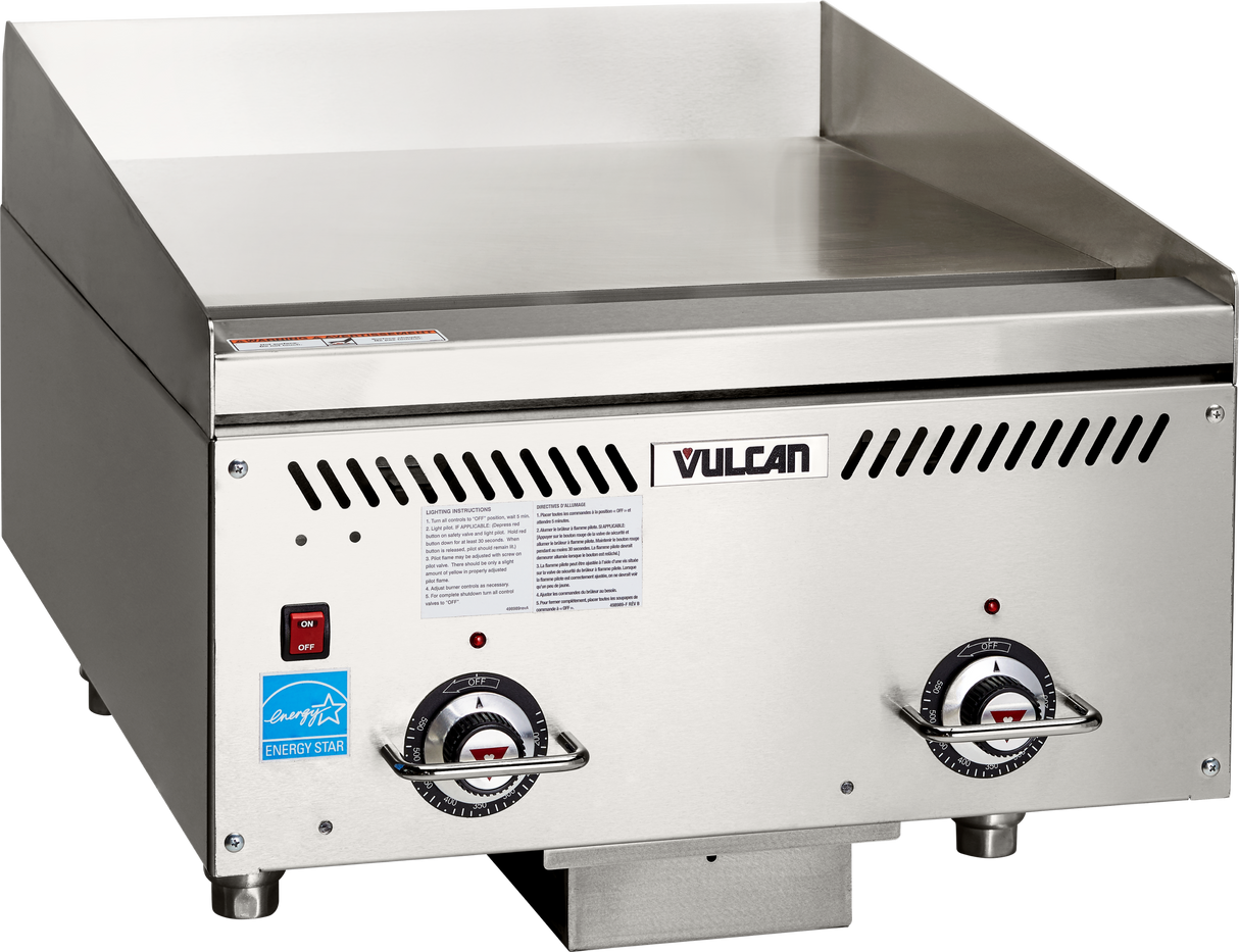 A stainless steel Vulcan heavy duty griddle with a flat cooking surface, two temperature control knobs, ventilation slots, and indicator lights. The front panel displays the Vulcan logo, safety instructions, and an Energy Star certification sticker.