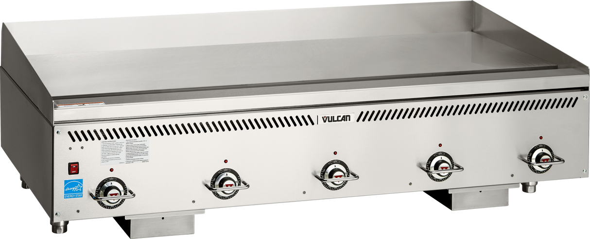 A large stainless steel Vulcan VCCG60-IC_LP gas countertop griddle with four control knobs, a raised backsplash, and flat heavy duty cooking surface. The front panel features ventilation slits, indicator labels, and the Vulcan brand name.
