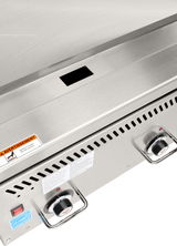 Close-up of a Vulcan VCCG24 heavy duty griddle’s control panel, featuring two black and red temperature knobs, a red power switch, ventilation slots, safety labels, and a small rectangular vent above the brushed metal surface.