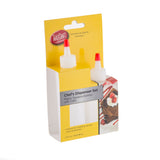 A yellow and white TableCraft Chef Squeeze Bottle Set package contains two dishwasher safe plastic bottles with red tips and white caps, designed for sauces or condiments. The packaging features a dessert image being drizzled and product details.