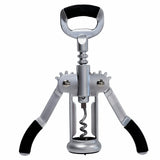 A TableCraft Products Premium Corkscrew with silver wings and black handles stands upright against a white background. The central screw and bottle opener top are visible, with both levers extended outward like arms.