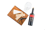 A wedge of brie cheese and seasoned crackers sit on a wooden board with a double hinged corkscrew. Beside them are an empty wine glass and a bottle of Red Rock Malbec wine, all set against a white background.