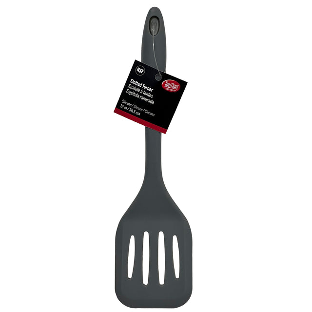 A gray silicone slotted spatula, heat resistant with a hole in the handle for hanging. A black and red product tag notes it’s a Cash & Carry Turner by Mainstays, with descriptions in English, Spanish, and French. Background is plain white.