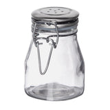 A clear, empty glass salt shaker jar with a wide base and a stainless steel clip top. The metal lid has small holes and is secured with a wire clasp. The jar is photographed against a plain white background.