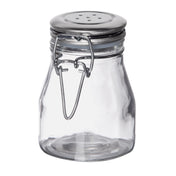A clear, empty glass salt shaker jar with a wide base and a stainless steel clip top. The metal lid has small holes and is secured with a wire clasp. The jar is photographed against a plain white background.