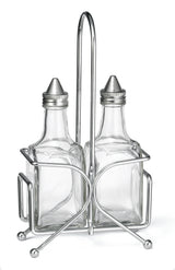 Two clear TableCraft glass bottles with metal pour spouts sit side by side in a silver geometric holder. Perfect as an Oil & Vinegar Dispenser Set, this stylish piece is ideal for any Cash & Carry setup. Bottles are empty; background is plain white.