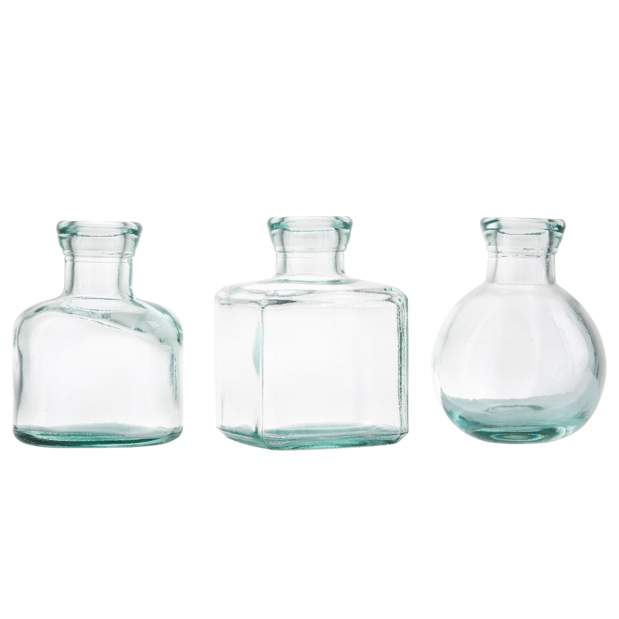 Three clear recycled glass bottles with short necks and wide mouths stand side by side. These versatile vases—cylindrical, square, and round—are empty, transparent, and set against a plain white background.
