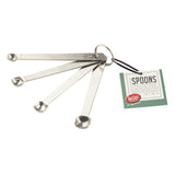 A set of four stainless steel measuring spoons labeled smidgen, pinch, dash, and tad, attached to a metal ring. Complements J.A. Henckels Steel tools perfectly. A green and white tag reads “Spoons, Stainless Steel, set of 4, For Craft Kitchen.”.