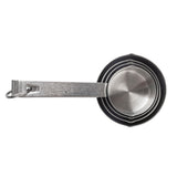 A stainless steel measuring cup set of four nests together on a white background. Held by a metal ring, each cup features etched measurement markings on the handles and is conveniently dishwasher safe.
