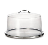 A round, stainless steel cake plate set with a transparent, dome-shaped plastic cover and small handle on top. The dishwasher safe cover sits securely on the tray, perfect for protecting and displaying cakes or pastries.
