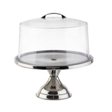 A shiny stainless steel cake stand with a wide base and flat plate, topped with a clear cake stand cover featuring a small handle. The stand is empty and isolated on a white background.