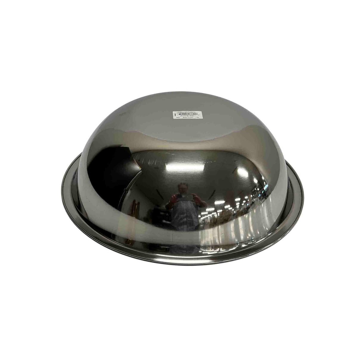 A large, round 8 qt stainless steel mixing bowl is turned upside down on a white background. The shiny surface reflects a distorted image of a person and ceiling lights, while a white barcode sticker is attached to the center.