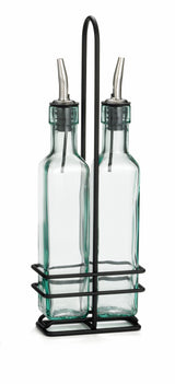 Two clear glass bottles with stainless steel pourers sit side by side in a sturdy metal rack with a handle. Perfect for dispensing oil and vinegar, these bottles add elegance to any kitchen. The minimalist design stands out against the white background.