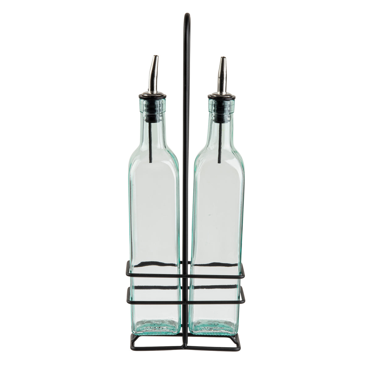 Two TableCraft Products green tint glass bottles with stainless steel pourers are placed side by side in a black metal stand with a handle. The rectangular bottles feature rounded shoulders, and the open stand has a minimalist design against a white background.
