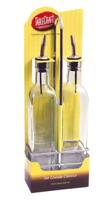 Two glass bottle set oil and vinegar bottles with stainless steel pourer spouts are held upright in a chrome plated rack. The yellow packaging features TABLECRAFT branding and the label Set Grande Classico at the bottom.