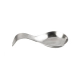 A dishwasher safe stainless steel spoon rest with a shallow, wide bowl and an upward-curved handle, designed for holding cooking utensils. The surface is smooth and shiny, set against a plain white background.