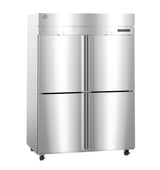 A large, stainless steel reach-in commercial refrigerator with four doors, two on top and two on the bottom, sits on small wheels. The metallic surface is reflective, with a digital control panel and a manufacturer logo near the top left corner.