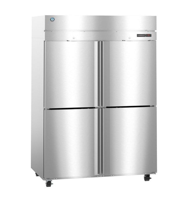A large, stainless steel reach-in commercial refrigerator with four doors, two on top and two on the bottom, sits on small wheels. The metallic surface is reflective, with a digital control panel and a manufacturer logo near the top left corner.