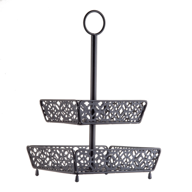 A two-tiered, black metal fruit basket with ornate, cut-out patterns on each tier. The rectangular trays are supported by a central pole and topped with a circular handle for easy carrying. Four small legs elevate the lower tier.