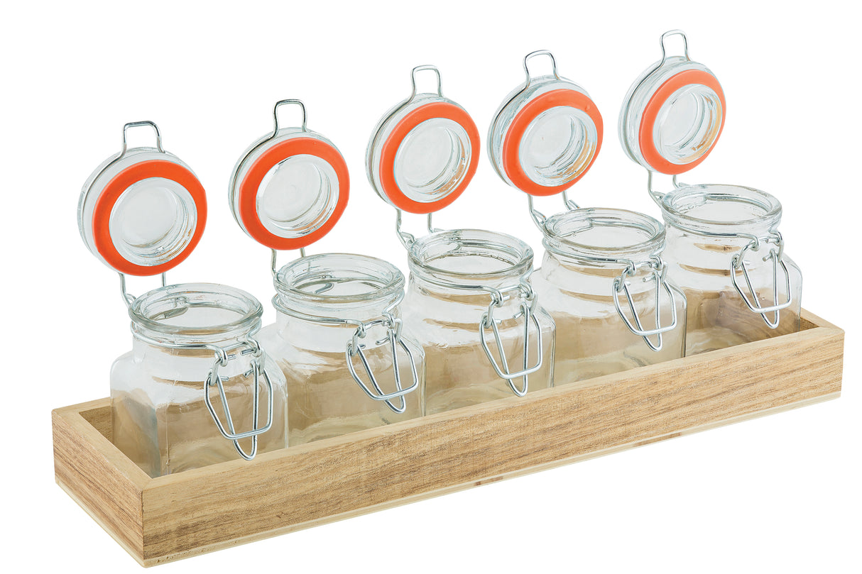 Five glass jars with metal clasps and orange seals are arranged in a single row on a wooden crate, their lids open and upright. This tasting flight set is ready to be filled, set against a crisp white background.