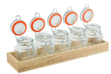 Five glass jars with metal clasps and orange seals are arranged in a single row on a wooden crate, their lids open and upright. This tasting flight set is ready to be filled, set against a crisp white background.