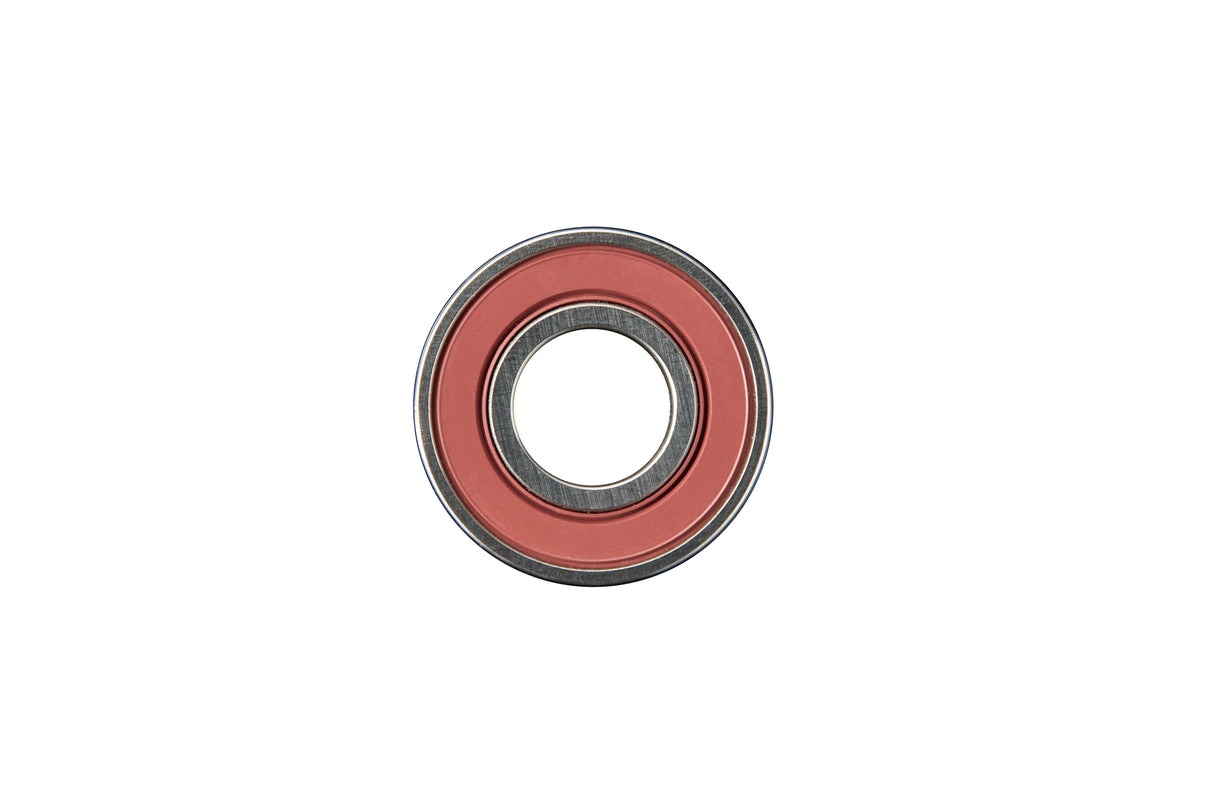 A close-up image of a ball bearing with a red outer ring and metallic inner parts, centered on a plain white background. Its precise, mechanical design evokes the engineering seen in modern appliances like nugget ice dispensers.