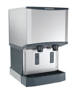 A sleek, industrial stainless steel ice and water dispenser offers nugget ice and water with two push levers labeled “ICE” and “WATER,” plus a black drip tray and side ventilation grates for efficient touchfree dispensing.