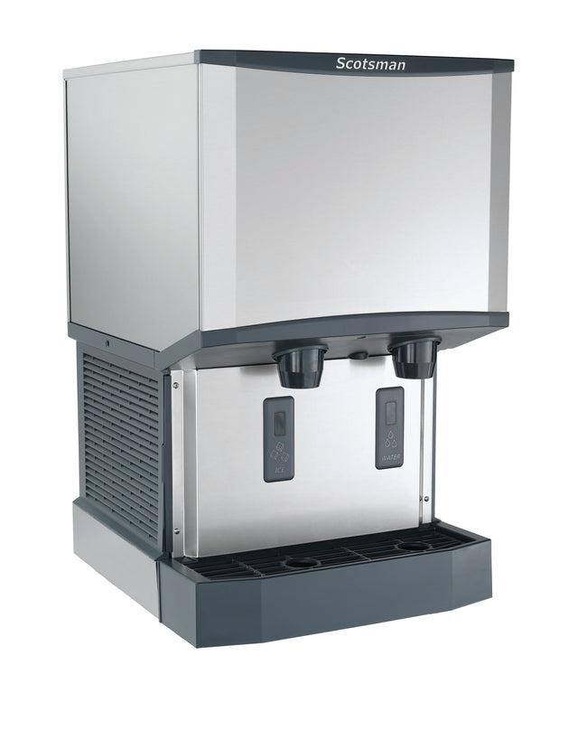 A sleek, industrial stainless steel ice and water dispenser offers nugget ice and water with two push levers labeled “ICE” and “WATER,” plus a black drip tray and side ventilation grates for efficient touchfree dispensing.