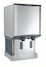 A stainless steel Scotsman ice and water dispenser with two black dispensers, digital display panels, and a rectangular, modern design. Featuring Touchfree infrared dispensing, the unit offers ventilation panels and a flat, reflective front surface.