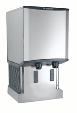 A commercial Meridian Ice & Water Dispenser made of stainless steel, with a boxy shape. It features touchfree infrared dispensing, two nozzles, and a black ventilated panel on the left side for cooling.