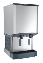 A stainless steel Scotsman ice and water dispenser with touchfree infrared dispensing, two digital displays, and a drip tray at the base. The sleek, boxy nugget ice machine is designed for countertop or freestanding use.