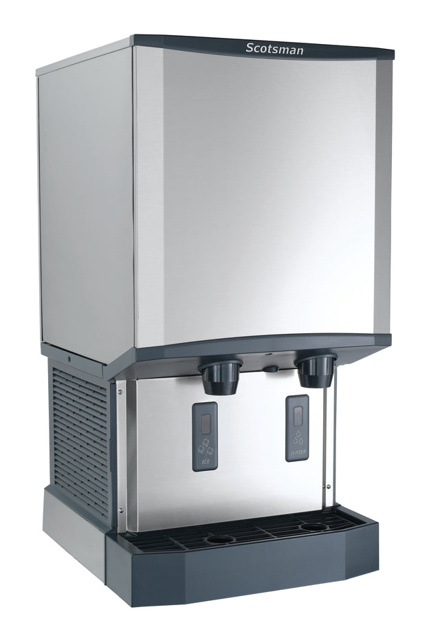 A stainless steel Scotsman ice and water dispenser with touchfree infrared dispensing, two digital displays, and a drip tray at the base. The sleek, boxy nugget ice machine is designed for countertop or freestanding use.