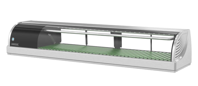 A stainless steel and glass Hoshizaki refrigerated sushi case with a green grooved base, designed for showcasing food items such as sushi. The case features rounded edges, a sliding glass door, and an interior shelf for organization.