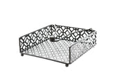 A black powder coated metal napkin holder from the TableCraft Farmhouse Collection features a geometric cut-out pattern, four round feet, and a weighted arm with a ball end to keep napkins in place. Photographed on a white background.