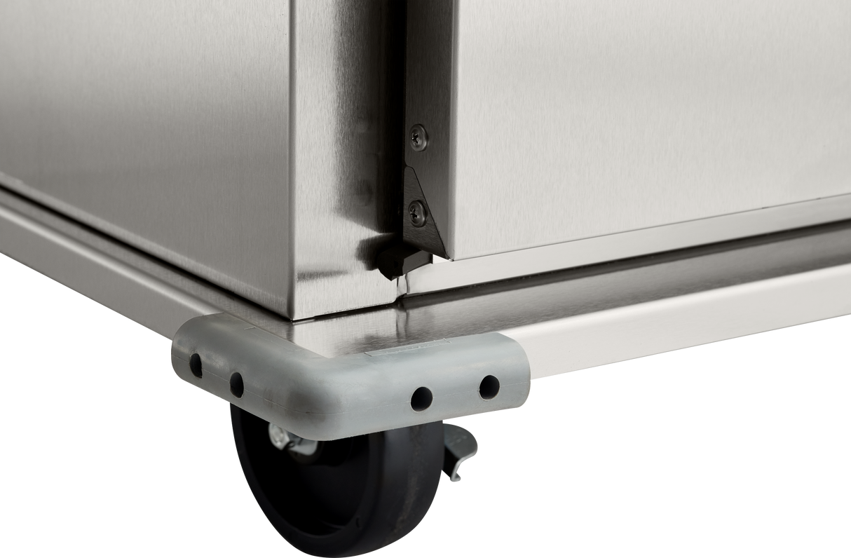 Close-up view of the bottom corner of a stainless steel institutional cabinet, showing a black caster wheel, protective gray corner bumper with black dots, and part of the metal frame with screws and joint details. The background is plain white.
