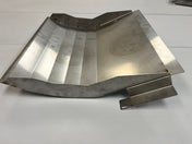A stainless steel, angular sheet metal component—possibly a bin deflector for upright bins by Icetro America—with multiple bends and flanges rests on a white surface. Subtle discoloration and faint circular marks hint at prior use or processing.