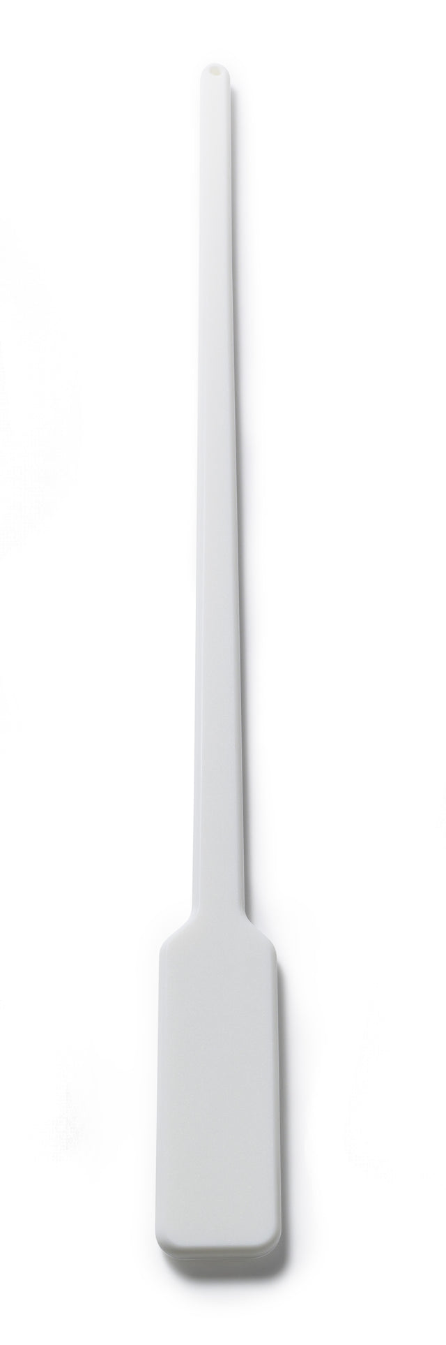A long white plastic spatula, resembling a Scotsman replacement paddle, with a rectangular flat blade and narrow handle lies flat on a white background. The handle has a small hole for hanging, and the design is simple and unadorned.