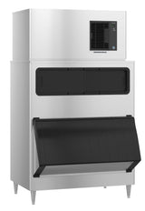 A large Hoshizaki cube-style ice maker with a stainless steel exterior, black vented panel on top, two black access doors in the middle, and a large open bin door at the bottom, all standing on four sturdy metal legs.